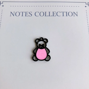 Détail d'un pendentif ours noir avec émail rose et perle pour création de bijoux DIY