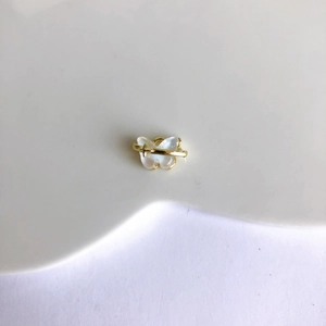Détail macro du pendentif papillon en résine irisée avec anneau orbital en métal doré