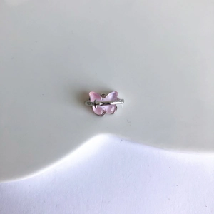 Vue macro détaillée du papillon en résine rose avec accents élégants en métal argenté
