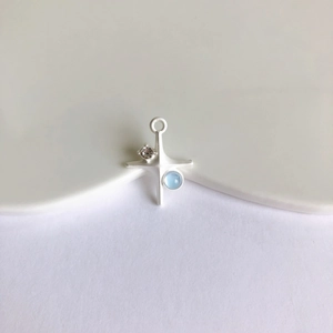 Detailed macro view of a matte silver star cross pendant with blue zircon for DIY jewelry