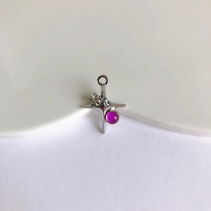Macro shot of silver alloy cross pendant with purple gemstone for DIY jewelry making