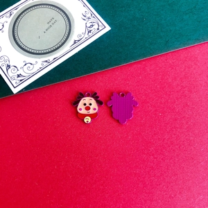 Close-up of a cartoon reindeer charm with purple and red enamel for DIY Christmas decor