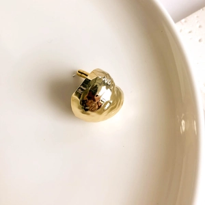 Macro detail of gold irregular textured stud earrings with a crumpled metal finish