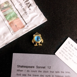Detail of single-eyed monster alloy charm with blue eye for DIY jewelry making