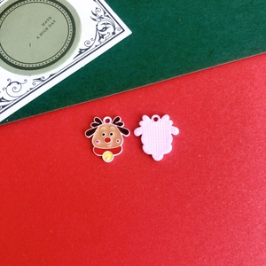 Detail of cartoon Christmas reindeer charms with colorful enamel finish and pink textured back
