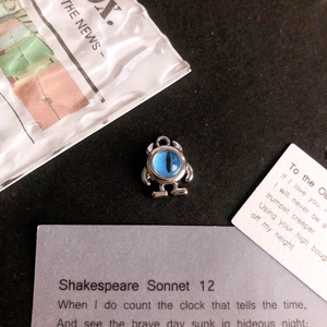 Detailed view of alloy monster pendant with blue cat eye stone on vintage background