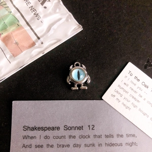 Close-up of a silver monster charm with a blue realistic eye for DIY jewelry making