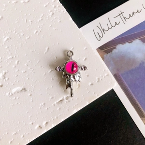 Dettaglio macro del ciondolo ad ala argento con occhio in resina rosa per gioielli