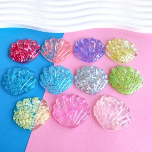 Dettaglio di 11 ciondoli a conchiglia in resina glitterata per accessori fai-da-te