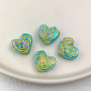 Close-up of heart-shaped iridescent blue rose beads with gold accents for DIY jewelry