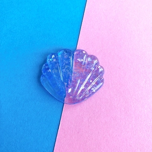 Dettaglio macro di un accessorio per capelli in resina a forma di conchiglia glitterata