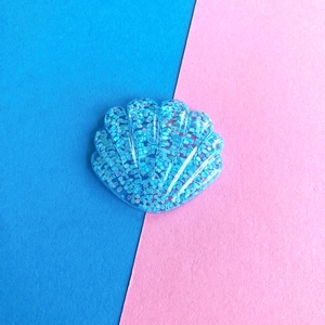 Dettaglio di un ciondolo a conchiglia in resina blu scintillante per fermagli per capelli