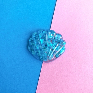 Dettaglio di una conchiglia in resina blu traslucida con glitter per accessori fai da te