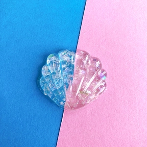 Dettaglio accessorio a conchiglia in resina glitterata con sfumatura blu e rosa