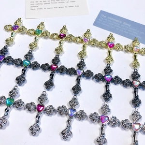 Detailed view of Gothic alloy cross pendants with roses and heart-shaped colorful gems