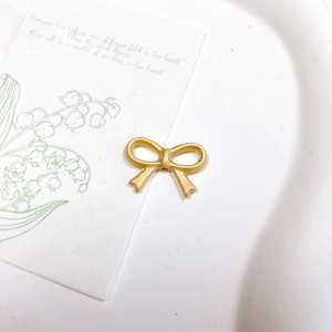 Détail macro d'une perle nœud dorée mate pour bijoux DIY avec trou de filetage central