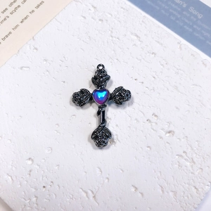 Macro detail of Gothic rose cross pendant with heart-shaped gemstone on stone stand