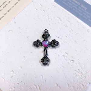 Detail showing Gothic cross pendant with rose patterns and heart-shaped purple gemstone