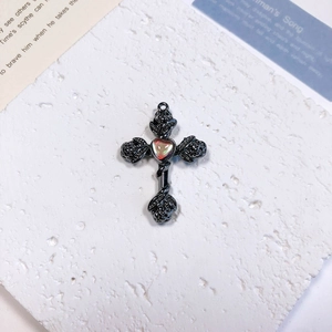 Detailed macro shot of gothic cross pendant with rose relief and rainbow heart stone
