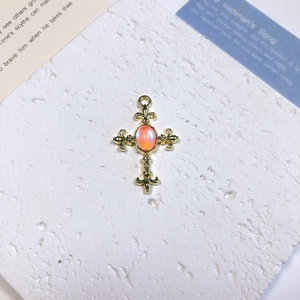 Detailed view of vintage gold cross pendant with oval opal stone and lily ends