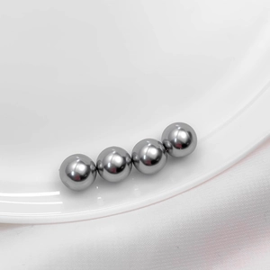 Close-up of four polished silver metal beads with a mirror finish for DIY jewelry