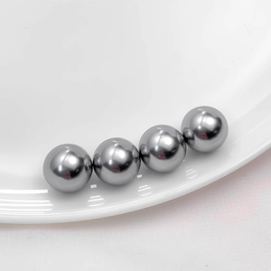 Macro shot of four polished dark grey acrylic glass pearls for DIY jewelry making