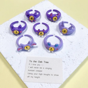 Detail van paarse monsterringen met gele ogen op wit gestructureerd stenen display