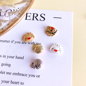 Macro detail of colorful alloy dragon egg and crab charms for DIY jewelry accessories