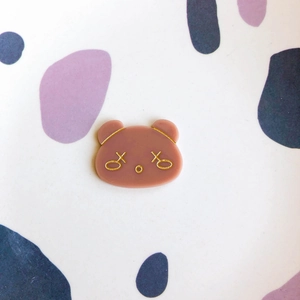 Detail shot of a cute cartoon bear acrylic DIY accessory with gold stamp face motifs