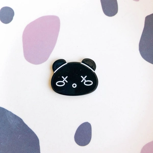 Detailed view of glossy black acrylic cartoon bear hair clip with trendy white outlines