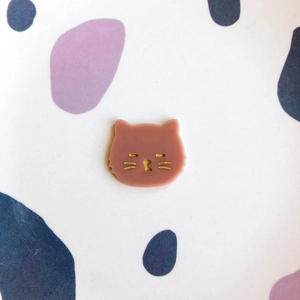 Détail d'une breloque chat en acrylique rose avec visage doré pour bijoux DIY