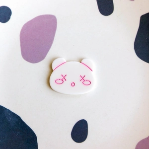 Macro view of a cute bear-shaped DIY resin accessory with a minimalist engraved pink face
