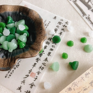 DIY lotus seedpod glass beads in green and white colors for jewelry and hair accessories