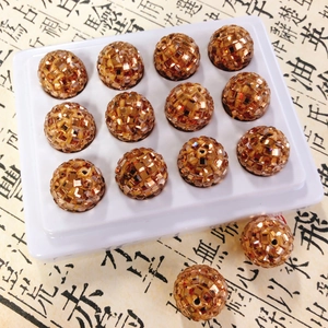 Macro shot of 14 bronze clay beads with sparkling sequins for DIY jewelry and phone charms