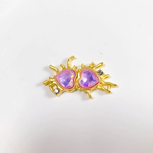 Detailed view of alloy double heart pendant with purple crystals and gold splash frame