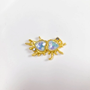 Close-up of golden fluid heart pendant with iridescent moonstone gems and crystals