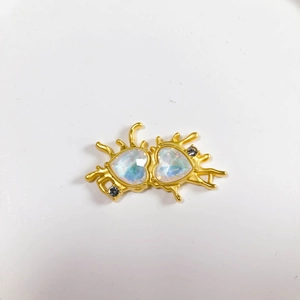 Macro view of gold liquid metal frame with twin iridescent heart crystals and rhinestones
