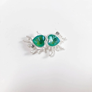 Detailed view of dual green heart crystals in a silver liquid metal alloy pendant
