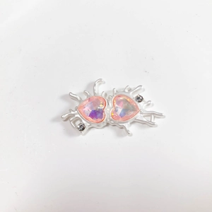 Detail of pink crystal double heart pendant with silver fluid metal frame and accent diamonds