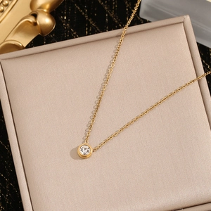 Elegant gold titanium necklace featuring a single round zircon pendant on a luxury display