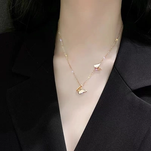 18k rose gold butterfly necklace with double pendants on a black suit background