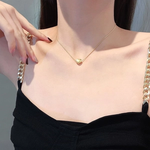 Minimalist gold heart pendant necklace on snake chain shown on model's neck