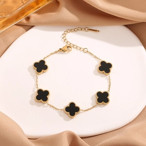 Golden 18K titanium steel clover bracelet with 5 black quatrefoil motifs and silk backdrop