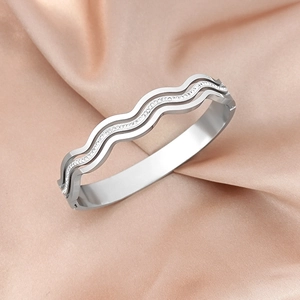 Close-up of silver wavy multilayer bangle with sparkling zircons on pink silk
