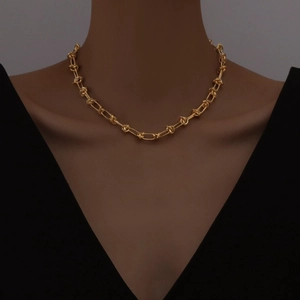 Minimalist punk knot chain necklace in matte gold finish worn by a fashion model