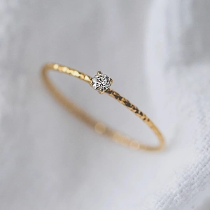 Anello sottile in oro 18k con piccolo diamante scintillante e trama in metallo martellato
