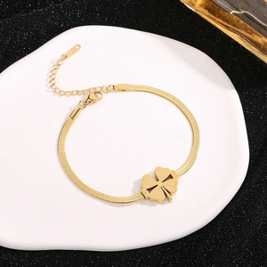 Bracciale a catena piatta color oro con ciondolo a quadrifoglio su vassoio bianco