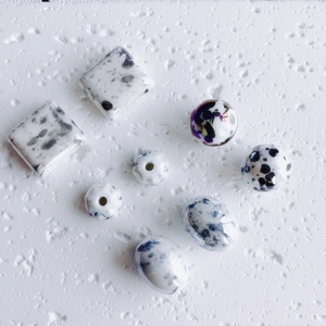 Detalle de cuentas de cerámica artesanales con patrón de tinta para joyería DIY