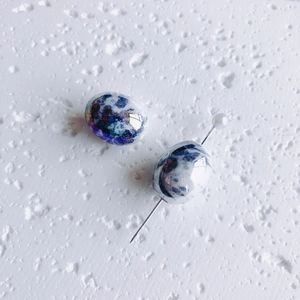 Detalle macro de cuentas de cerámica artesanales con esmalte jaspeado azul para joyería DIY