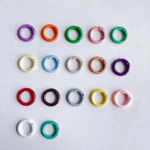 Flat lay of colorful 20mm round metal spring gate rings in 17 painted finish colors